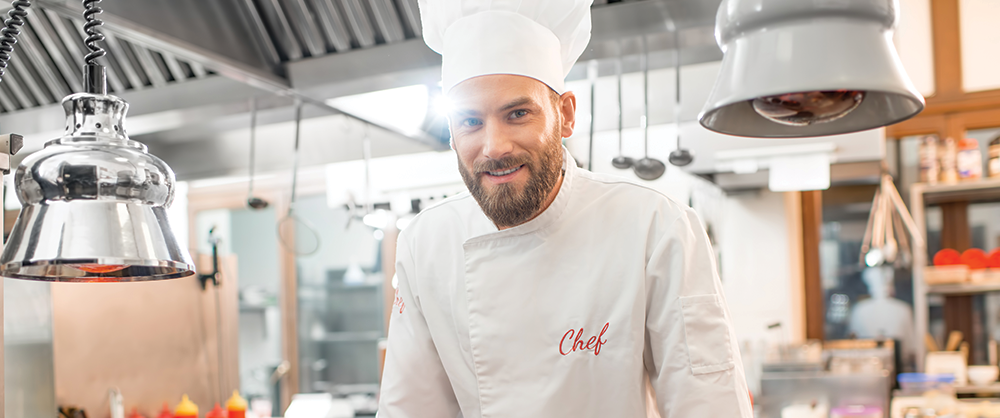 Smiling chef standing in bright kitchen